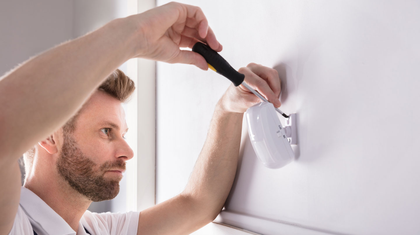 Détecteur de mouvement incorrectement installé face à un radiateur, illustrant une erreur typique de positionnement